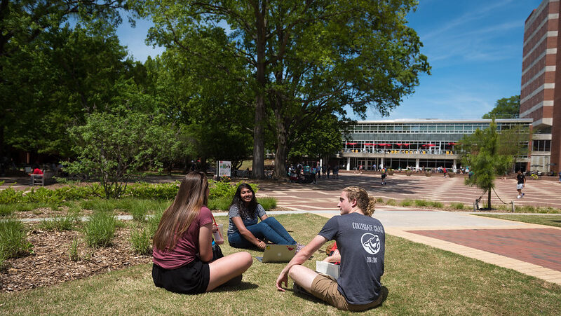 Students sit outside in the Brickyard